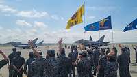 Japanische Soldaten stehen winkend zu deutschen Eurofightern gerichtet. 