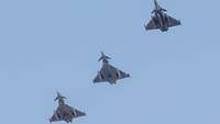 Three fighter jets in flight at an angle.