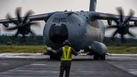 A soldier stands in front of an A400M.