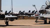 Different fighter jets on a concrete surface.