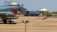 In the foreground is a fighter jet, while in the background is a transport plane.