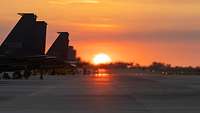 Finns of fighter jets as the sun sets.