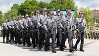 Soldaten marschieren in Formation über einen Platz