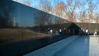 In der schwarzen Wand des Vietnam Veterans Memorial spiegelt sich das Washington Monument.