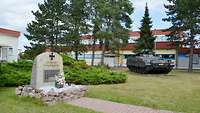 Ein Gedenkstein und ein Schützenpanzer Marder am Haupteingang einer Kaserne