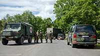 Mehrere Soldaten und Fahrzeuge während einer Unfallübungssituation.