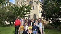 Die Teilnehmer stehen auf einer Wiese vor der Kathedrale