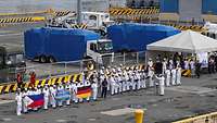 Philippinische Soldaten in weißer Uniform stehen zur Begrüßung aufgereiht auf einer Pier.