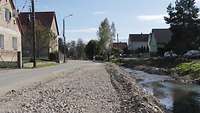 Blick auf eine Straße, neben der ein schmaler Fluss läuft