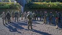 Soldaten verschiedener Nationen werden vom deutschen Trainingsleiter in den Tagesablauf eingewiesen.