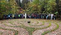 Viele Menschen stehen vor einem Labyrinth.