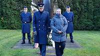 Ein Mann und eine Frau vor einer Gedenksäule