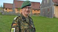 Ein Soldat mit grünem Barett schaut freundlich zum Porträt in die Kamera.