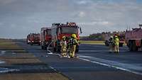 Brandschützer und ihre Fahrzeuge bei einer Übung auf dem Rollfeld.