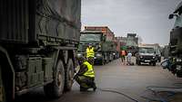 Soldaten prüfen den Reifendruck der Lkw.