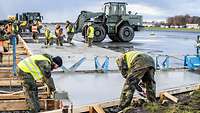 Luftwaffenpioniere befestigen den neuen Beton für die Landebahn.