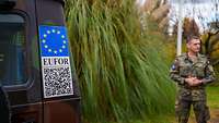 Eine Aufnahme von einem QR-Code Aufkleber auf einem Greenliner mit Euro-Flagge und auf der EUFOR steht.