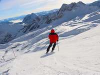 Ein Sportler fährt auf Skiern einen Hang hinunter