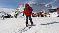 Ein Sportler steht auf Skiern am Hang