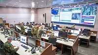 Several military personnel in an operations centre