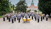 Die Musikerinnen und Musiker vor dem historischen Rathaus mit See davor