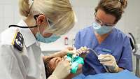 Zahnärztin und ihre Assistentin während einer Behandlung