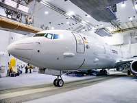 Ein weißes Flugzeug der Deutschen Marine steht in einem Hangar.