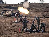 Soldaten schießen aus einer Mörserstellung heraus.