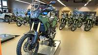 Mehrere Motorräder Yamaha Ténéré 700 in olivgrün stehen in einer Werkstatthalle