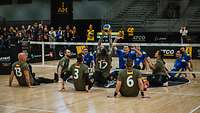 Deutsche und ukrainische Sportler spielen Sitzvolleyball in einer Halle