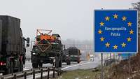 Militärische Fahrzeuge fahren hintereinander auf der Autobahn an einem polnischen Grenzübergangsschild vorbei.