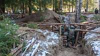 Mehrere Soldaten bauen einen Graben im Wald