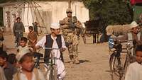 Ein Soldat läuft durch ein Dorf in Afghanistan 