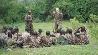 Ein deutscher Soldat spricht zu einer Gruppe somalischer Soldaten 