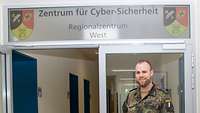 Schäfer steht vor dem Eingangsbereich des Regionalzentrum West, Zentrum für Cyber-Sicherheit der Bundeswehr 