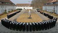 Mehrere Soldaten sind in einer U-förmigen Formation angetreten.