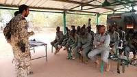 Ein Deutscher Rettungssanitäter vermittelt malischen Soldaten medizinische Grundsätze im Außenklassenzimmer.