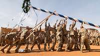 Soldaten stellen Maibaum auf