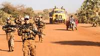 Soldaten und zivile Fahrzeuge auf der Straße.