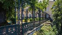 Schmiedeeiserne Pergola mit dem Schloß im Hintergrund