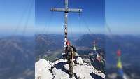 Ein Soldat steht neben dem Gipfelkreuz auf der Alpspitze mit Blick auf Garmisch-Partenkirchen