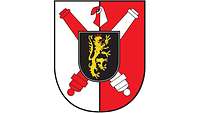 Auf Rot-silber: Gekreuzte Rohre als Zeichen der Artillerie, darauf schwarzes Wappen mit Pfälzer Löwe