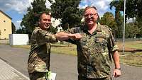 Colonel Sarmiento und Generalarzt Dr. Kowitz begrüßen sich mit den Ellenbogen anstatt mit einem Handschlag