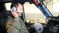 Der Pilot setzt den A400M-Helm ab und setzt sich ein Headset auf.