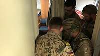 Ein deutscher Ausbilder steht mit libanesischen Soldaten in einem Gang des Schiffes