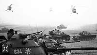 Schwarz-Weiß-Aufnahme von Kampfpanzern Typ M 48 und Hubschraubern Typ Sikorsky H-34 G beim Manöver „Panthersprung“