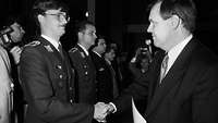 Verteidigungsminister Rühe schüttelt einem Soldaten die Hand