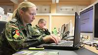 Eine Soldatin sitzt an einem Computer