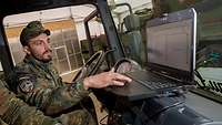 Ein Soldat in einem Fahrzeug mit einem Computer