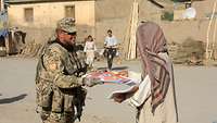 Ein Soldat verteilt Zeitungen 
